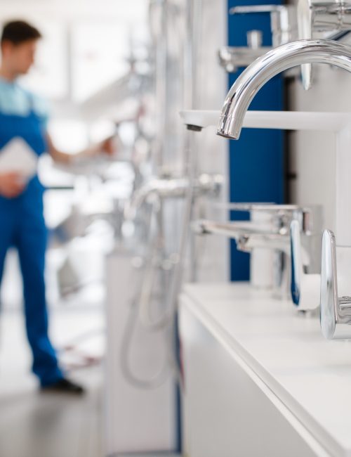 plumber-choosing-faucet-in-plumbering-store-B5JHUVD plumber-choosing-faucet-in-plumbering-store-B5JHUVD